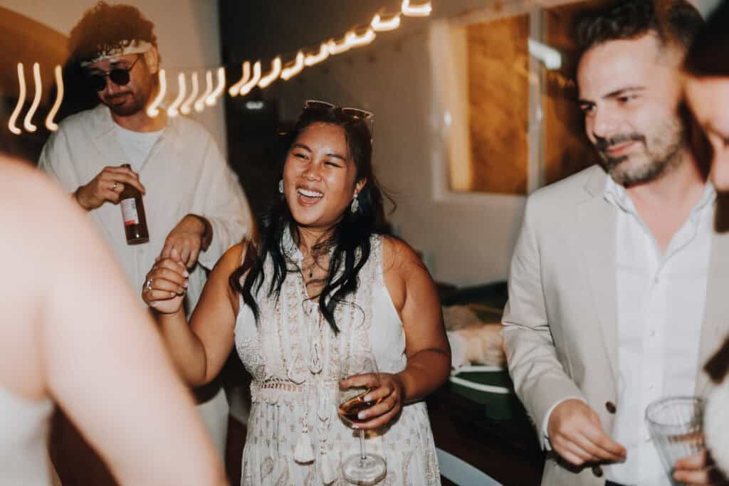 Lachende Frau mit Glas auf Party. Hochzeitsfotograf Ibiza könnte solche Momente festhalten.