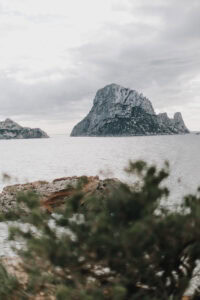 Felsinsel Es Vedrà, Ibiza, im Meer unter bewölktem Himmel. Küstenlandschaft.
