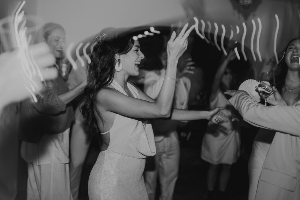 Fröhliche Frau tanzt mit Freunden auf einer Party.