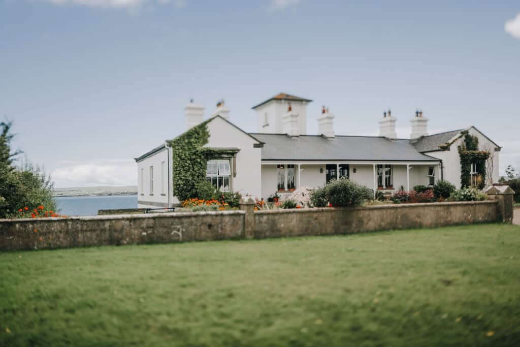 Weißes Haus mit Garten in Irland am Meer. 