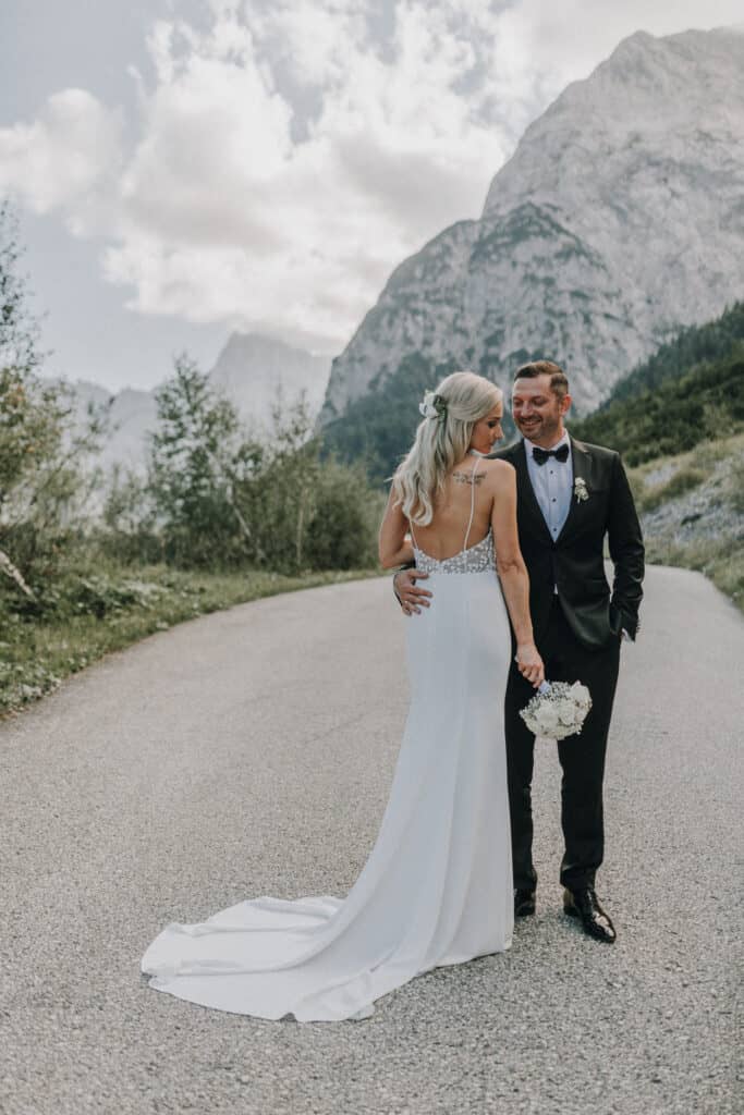 Brautpaar umarmt sich vor Bergkulisse in Tirol. Hochzeit in den Alpen.