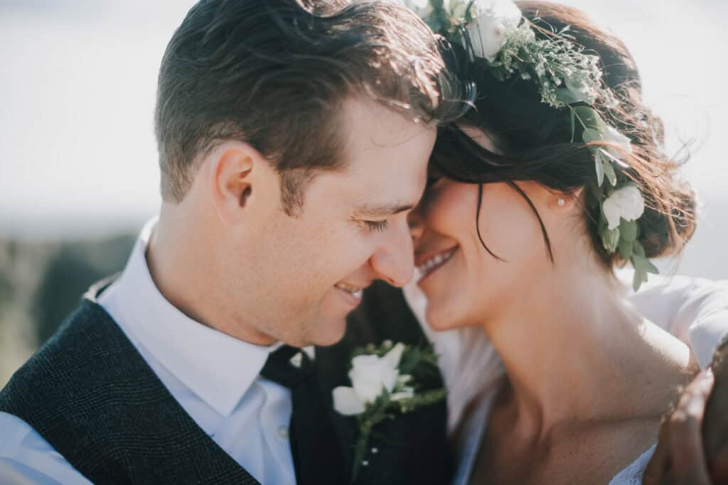Glückliches Brautpaar kuschelt. Braut mit Blumenkranz. Hochzeitsfotograf Irland.