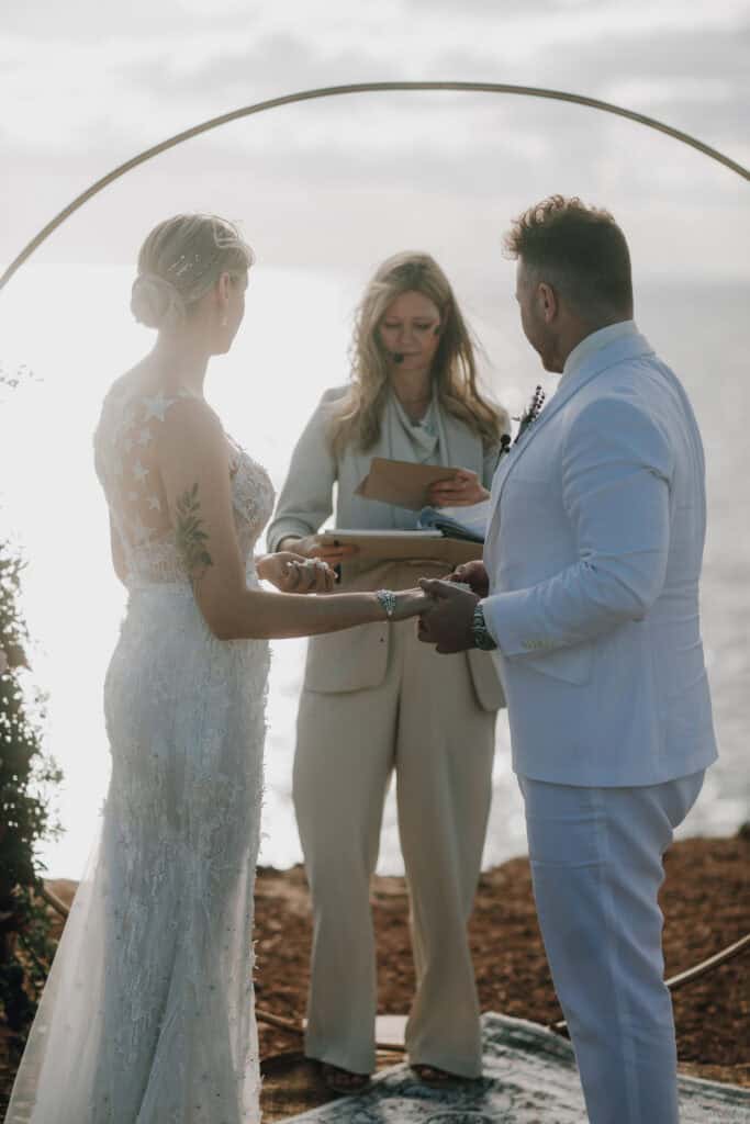 Brautpaar bei Zeremonie im Freien auf Ibiza. Hochzeit im Boho-Stil mit Meerblick.