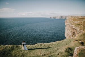 Brautpaar umarmt sich auf den Klippen von Moher, Irland. Atlantik im Hintergrund.