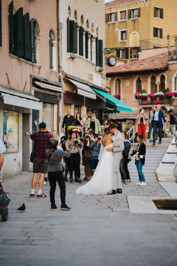 Hochzeitspaar küsst sich in Venedig, umgeben von Fotografen. Workshop für Hochzeitsfotografen.