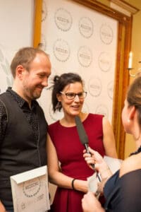 Paar erhält Interview mit Mikrofon, hält "Wedding Award 2017"-Auszeichnung. Festliche Veranstaltung.
