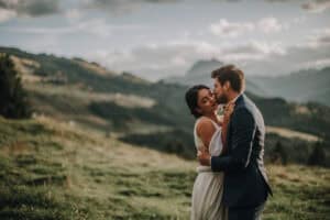 Brautpaar umarmt sich innig vor Bergkulisse in Tirol. Romantische Hochzeit in den Alpen.