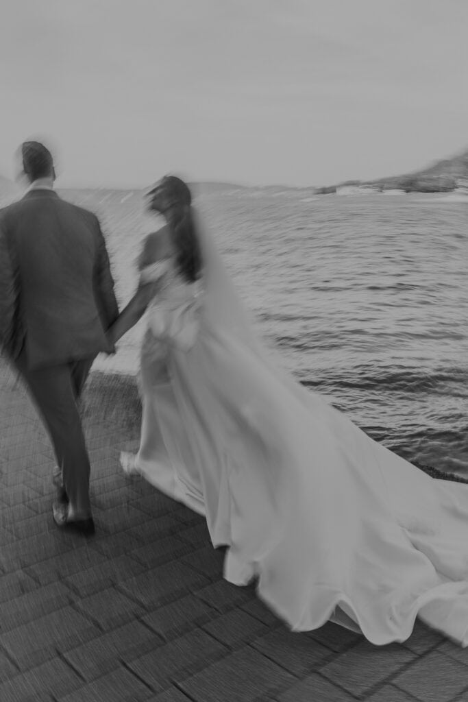 Brautpaar Hand in Hand am Meer. Hochzeitsfotograf Tirol könnte ähnliche Momente festhalten.