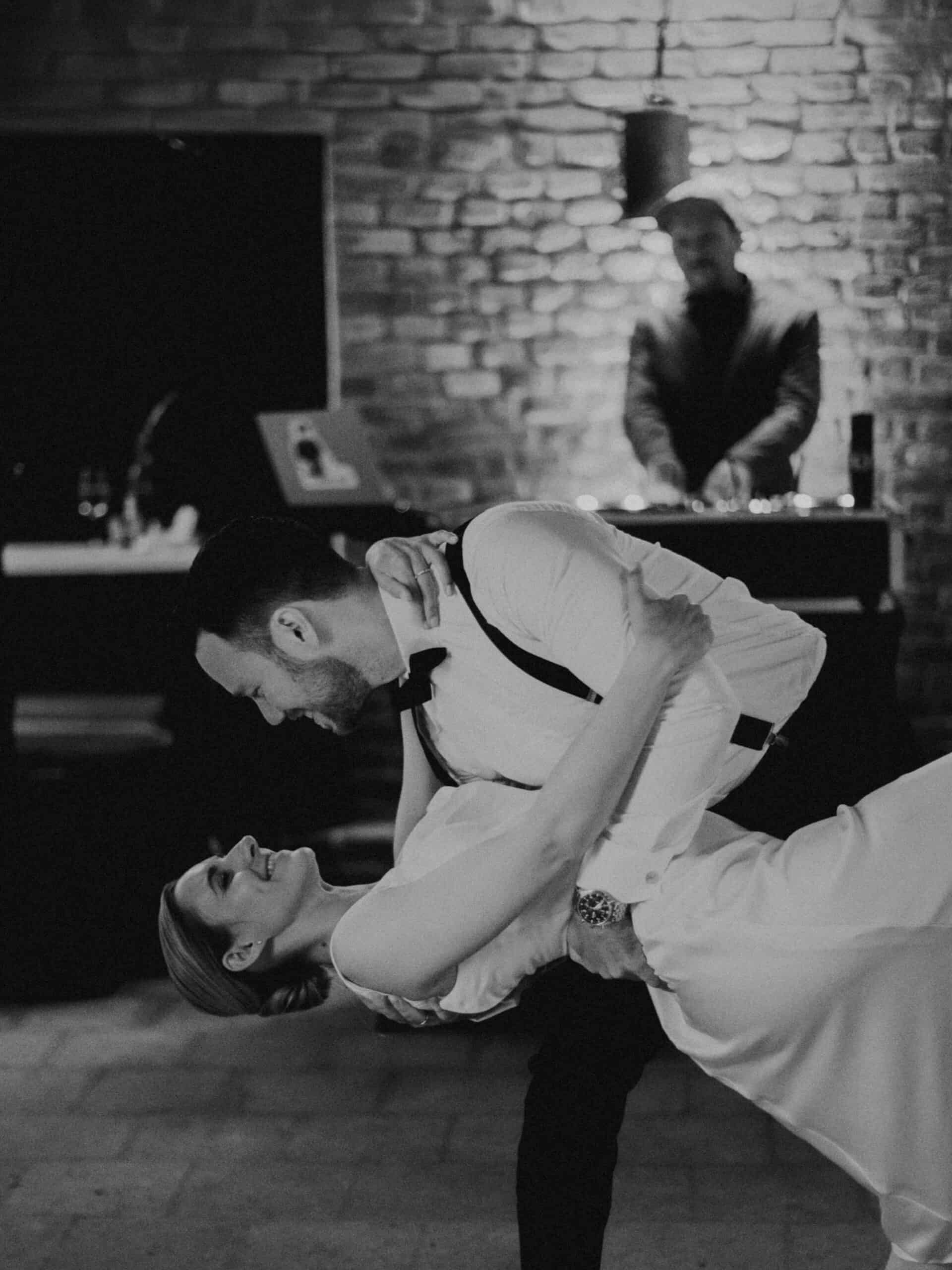 Brautpaar tanzt, Bräutigam hält Braut im Arm, DJ im Hintergrund. Hochzeit Tirol.