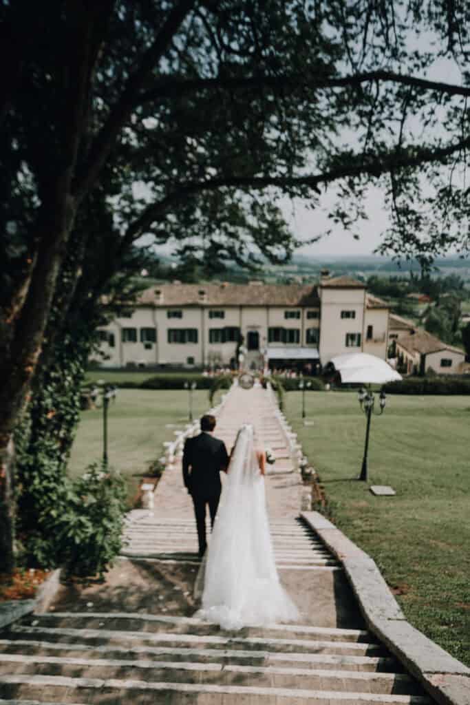 Brautpaar geht auf Treppe zu toskanischer Villa. Hochzeit in der Toskana.