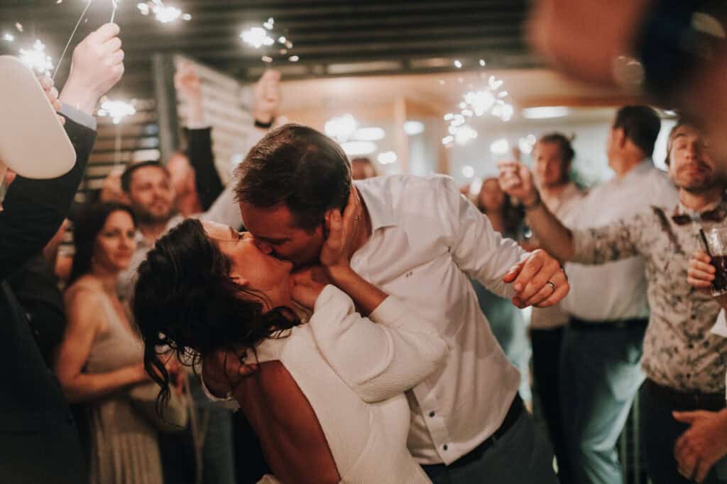 Brautpaar küsst sich inmitten von Wunderkerzen. Hochzeitsfotograf Tirol. Glückliche Hochzeit.