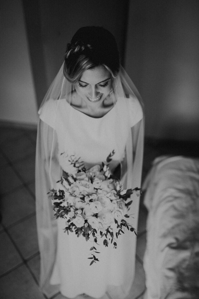 Braut mit Brautstrauß und Schleier, Blick nach unten. Hochzeit Foto und Film Europa.